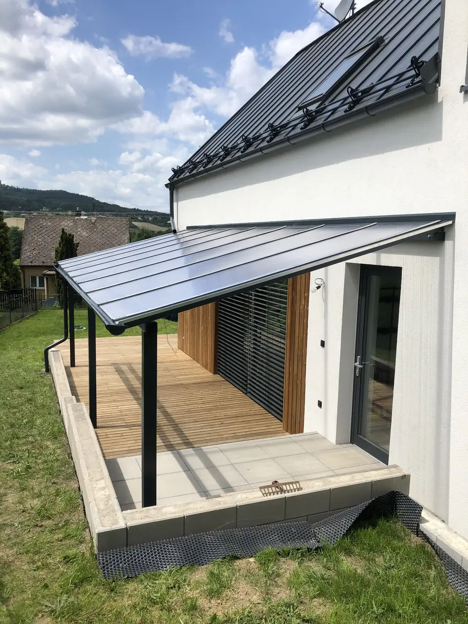 Zastřešená pergola nad dřevěnou terasou